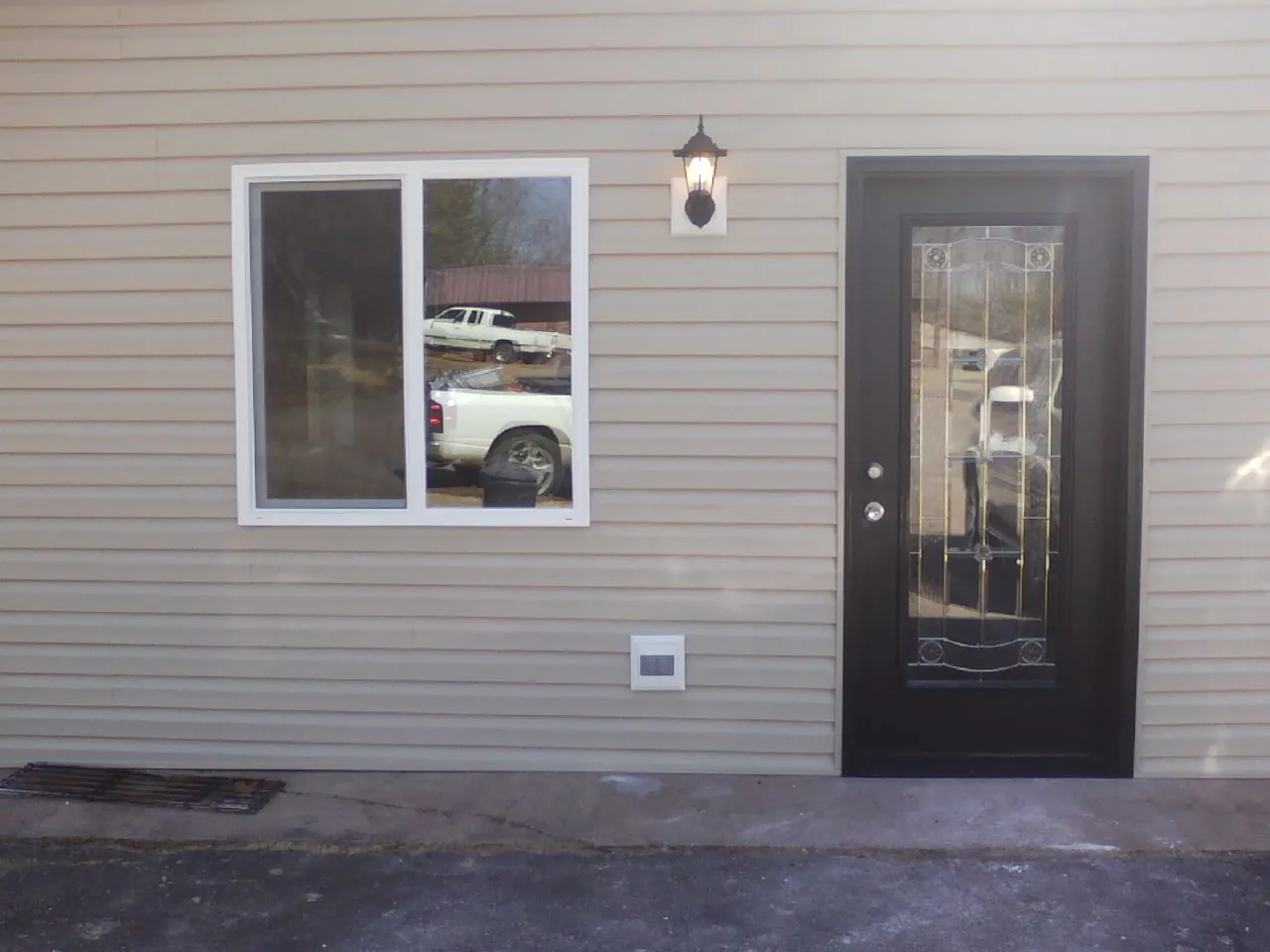 New siding, window and entry door on the side of an addition in Harwick