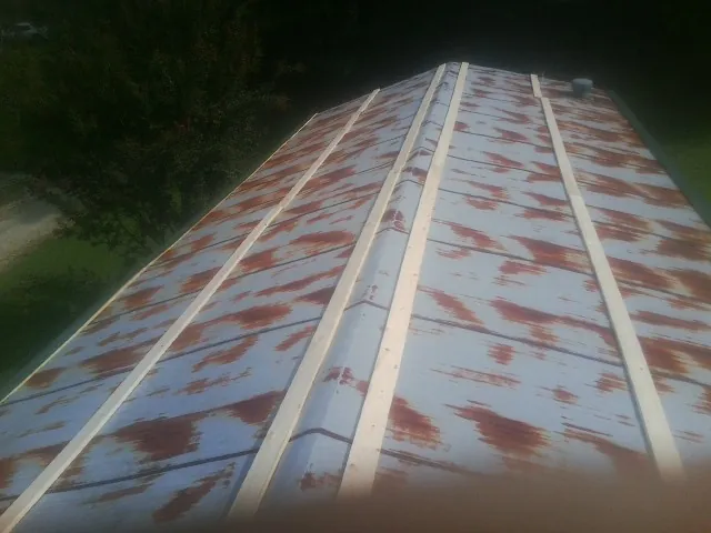 Rusted metal roof panels with new wood purlins before replacement — Storm Damage Roof Repair in Harwick by Roofing Brothers