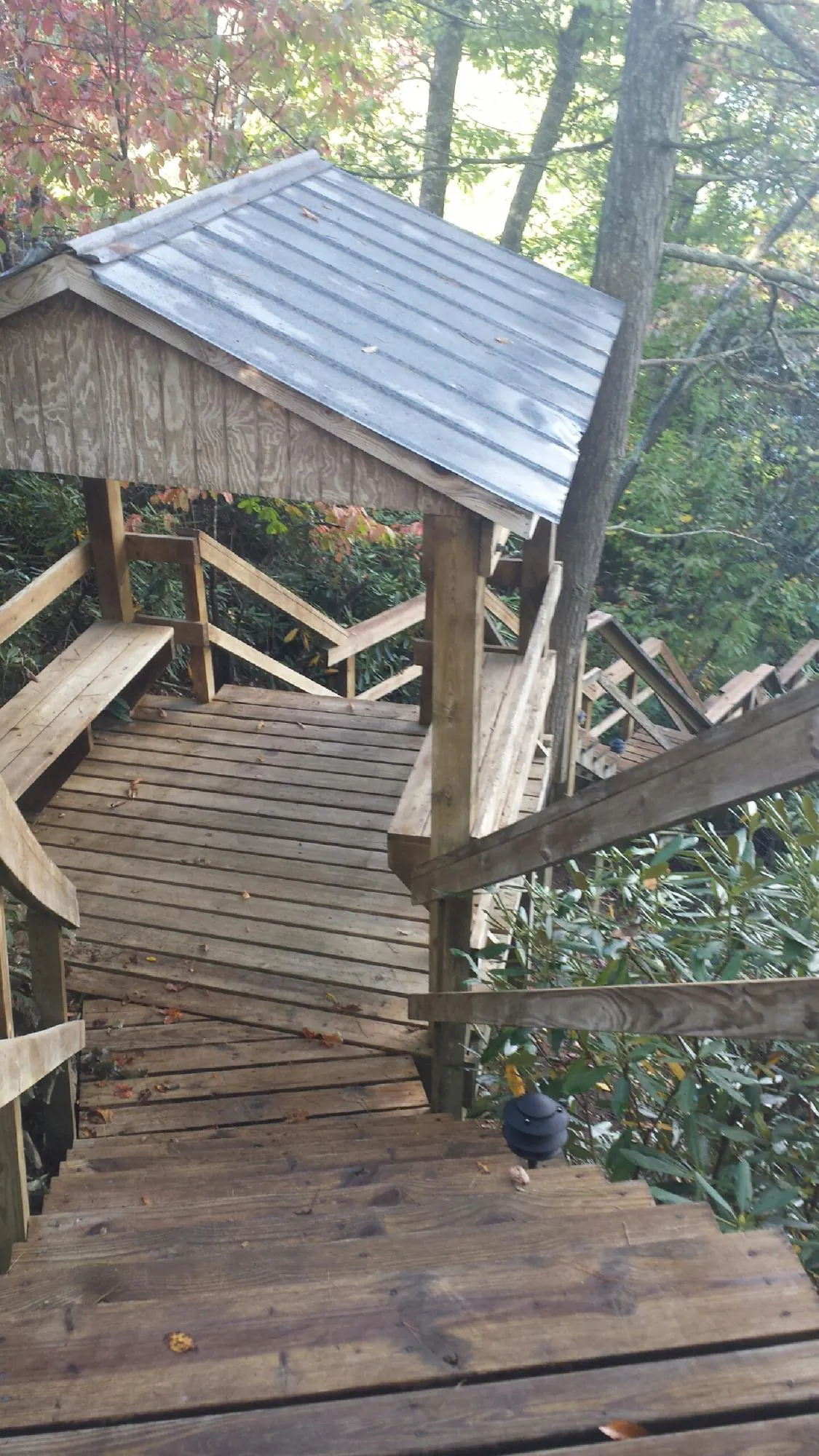Metal roofed shelter over wooden steps on a wooded walkway — Skylight Repair & Installation work by our crew in Harwick